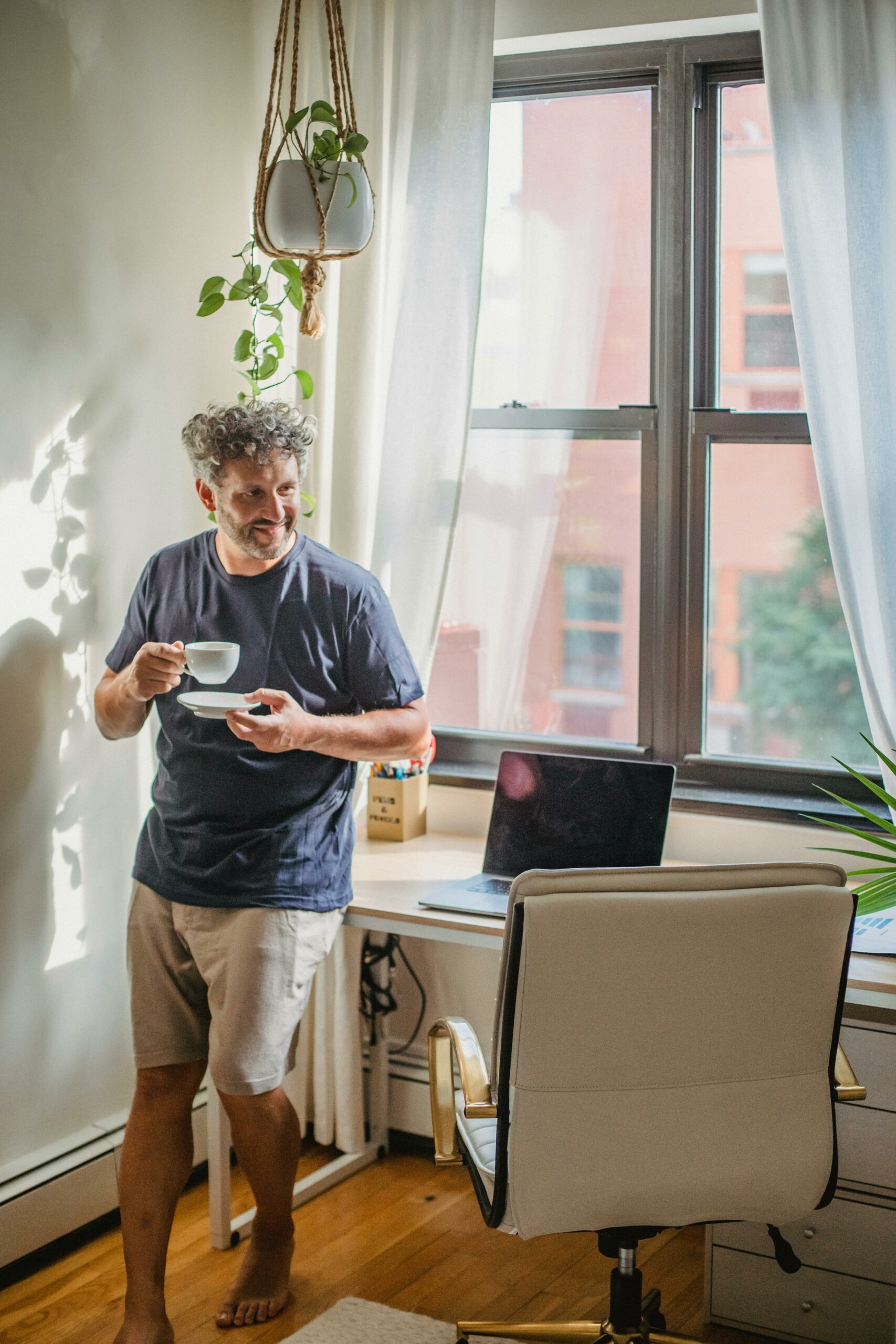 Man taking a break from working at home to drink some coffee.