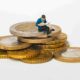 living generously man sitting on coins